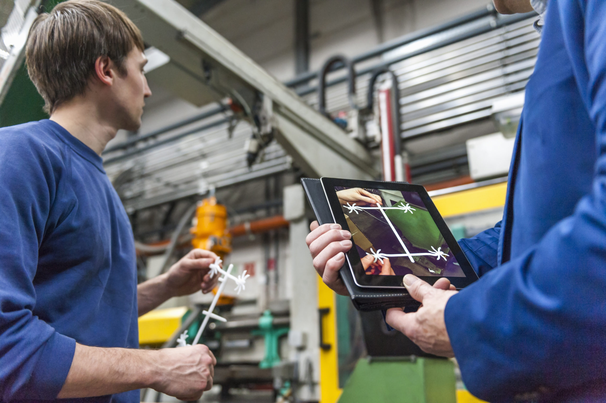 Manager and worker examining products in plastcs factory
